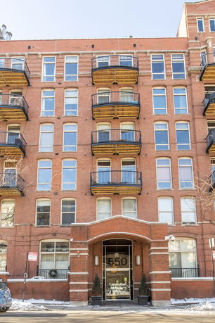 Front view of a multi-story brick building with balconies.