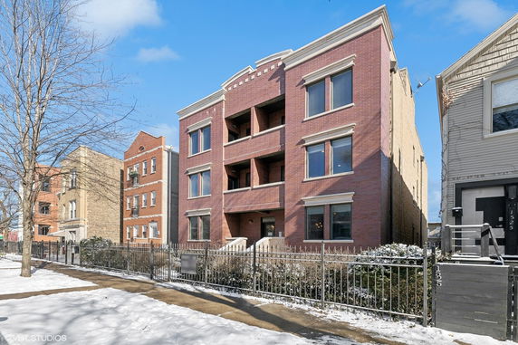 Front view of a multi-story brick building with balconies.