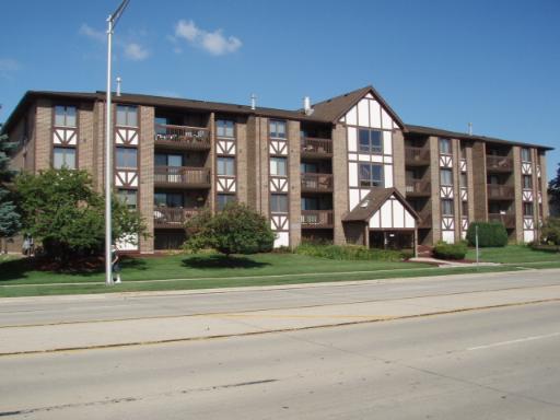 Front view of a multi-story apartment building with balconies.