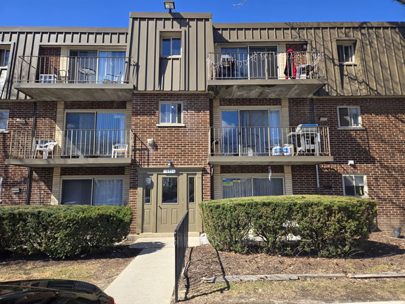 Front view of a three-story apartment building with balconies.