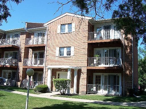 Front view of a multi-story apartment building with balconies.