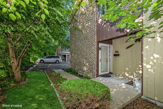 Front view of a house with a brick wall and a covered entrance.