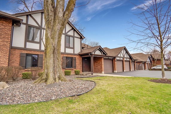 Front view of a multi-garage brick building with a Tudor-style exterior.