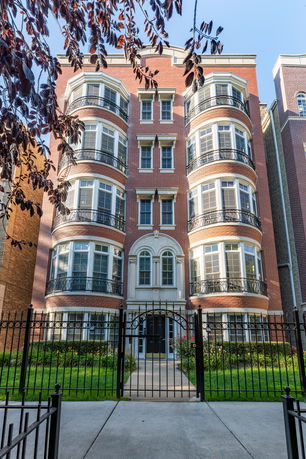 Front view of a multi-story apartment building with balconies.