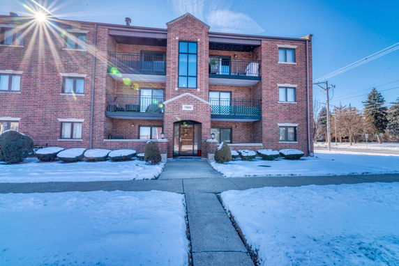 Front view of a multi-story brick building with balconies.