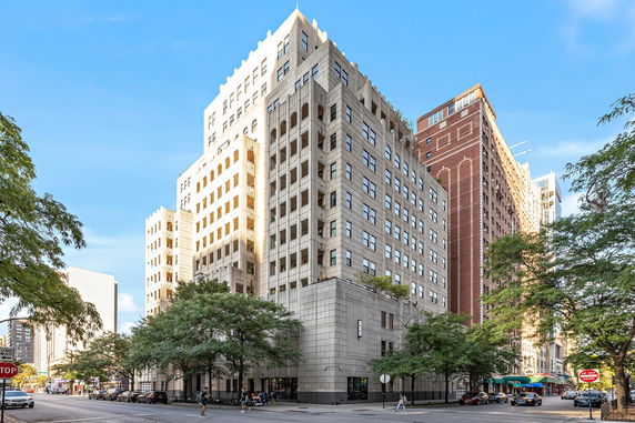 Front view of a multi-story building on a city street corner.