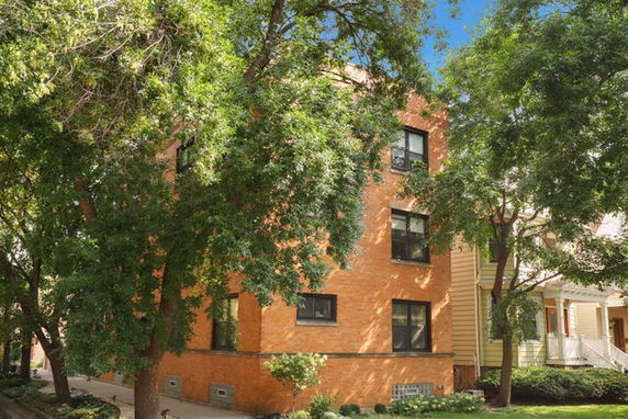 Front view of a multi-story brick building with multiple windows.