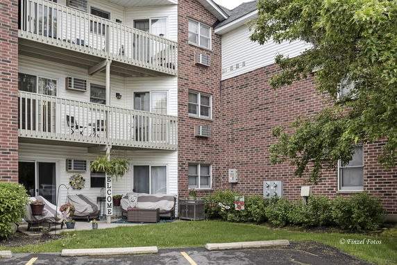 Front view of a multi-story building with balconies and brick exterior.
