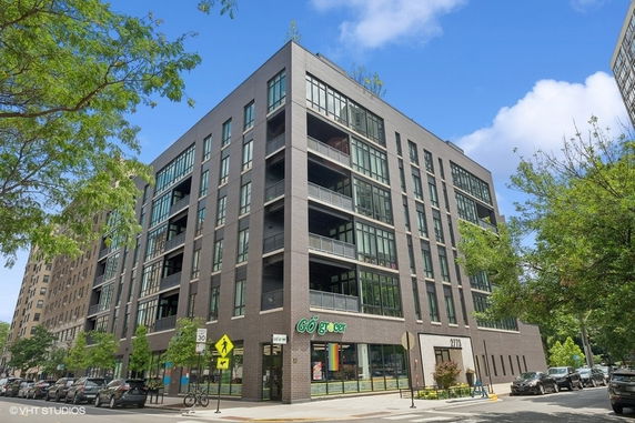 Front view of a multi-story apartment building with large windows and balconies.