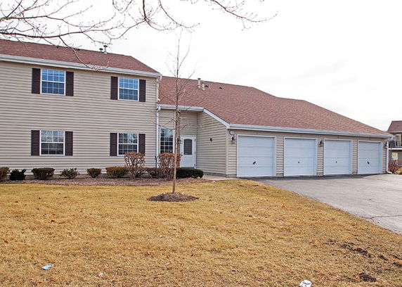 Front view of a two-story house with three garage doors.