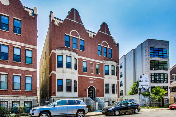 Front view of a multi-story brick building with decorative elements.