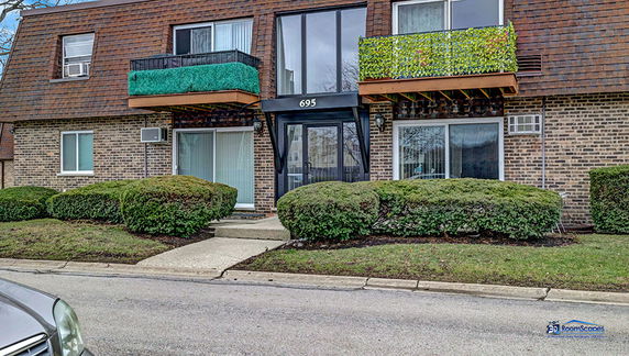Front view of a two-story brick residential building with balconies.