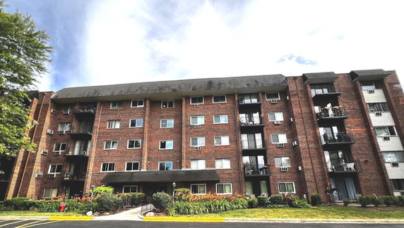 Front view of a multi-story brick apartment building.