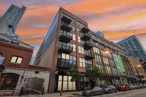 Front view of a multistory building with balconies and large windows.