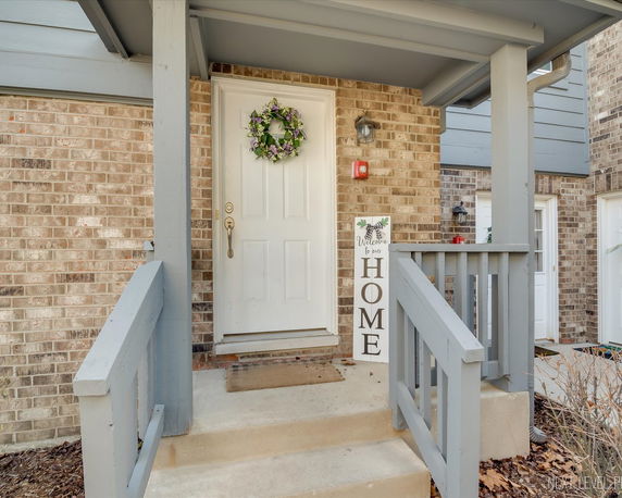 Front entrance of a house with a white door and a small porch.