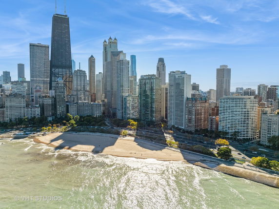 Panoramic view of a city skyline with high-rise buildings and a beachfront.