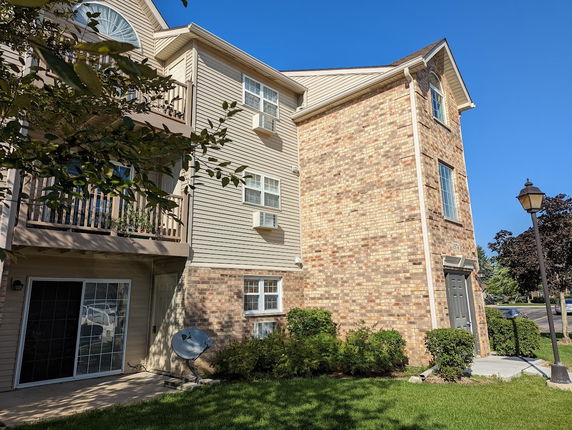 Front view of a multi-story building with a brick facade and balconies.