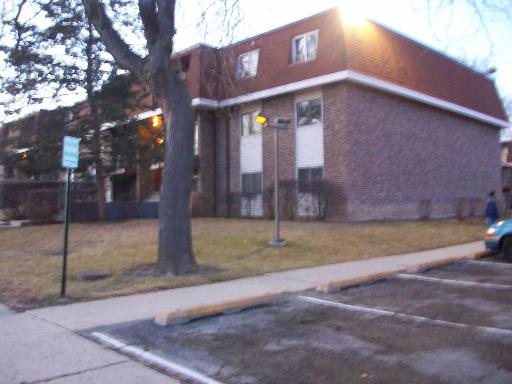Front view of a multi-story brick building with a sloped roof.