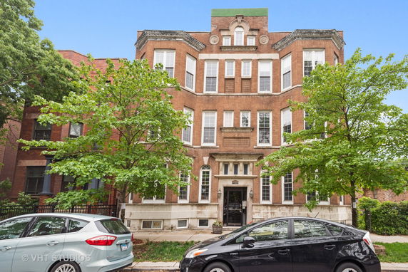 Front view of a multi-story brick building with multiple windows and an entrance.