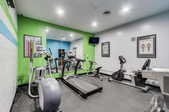 Indoor gym area with exercise equipment including treadmill, elliptical, and exercise bikes.