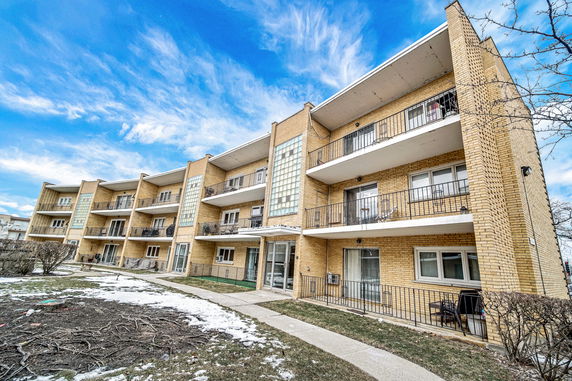 Front view of a three-story apartment building with balconies.