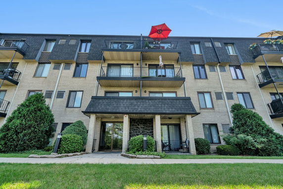 Front view of a multi-story apartment building with balconies.