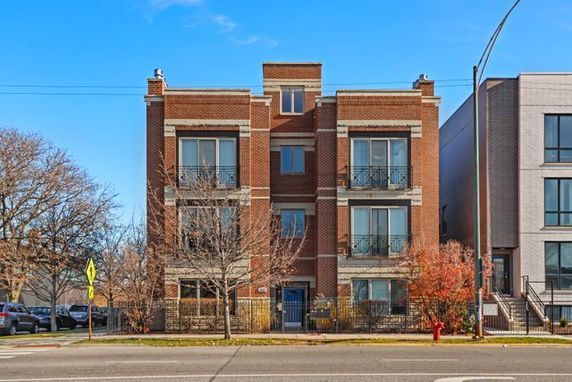 Front view of a multi-story brick apartment building.
