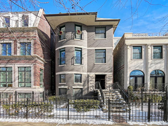 Front view of a multi-story brick building with a staircase entrance.