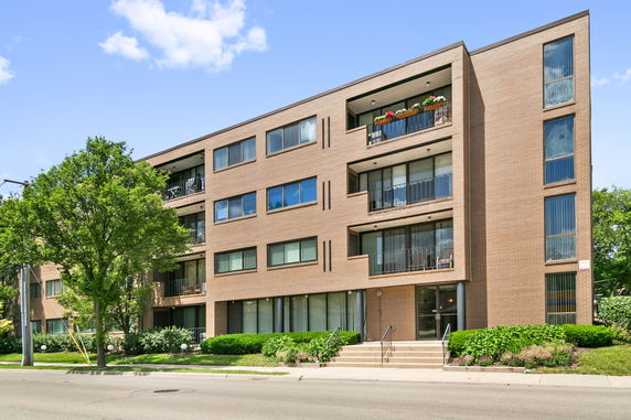 Front view of a multi-story apartment building with balconies.