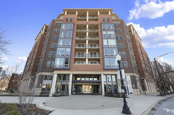 Front view of a multi-story apartment building with large windows and balconies.