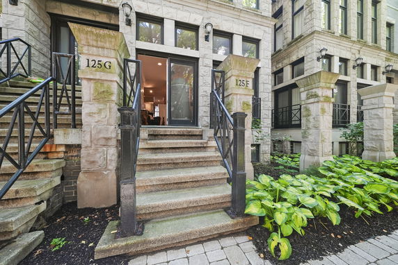 Front view of a multi-story building with stone steps and metal railings.