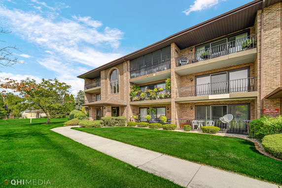 Front view of a multi-story brick building with balconies.