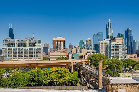 Panoramic view of a cityscape with tall buildings and a railway track.