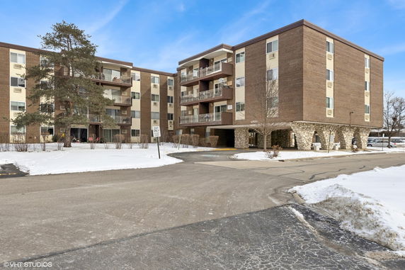 Front view of a multi-story apartment building with balconies.