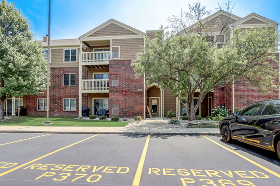 Front view of a multi-story residential building with balconies and brick facade.