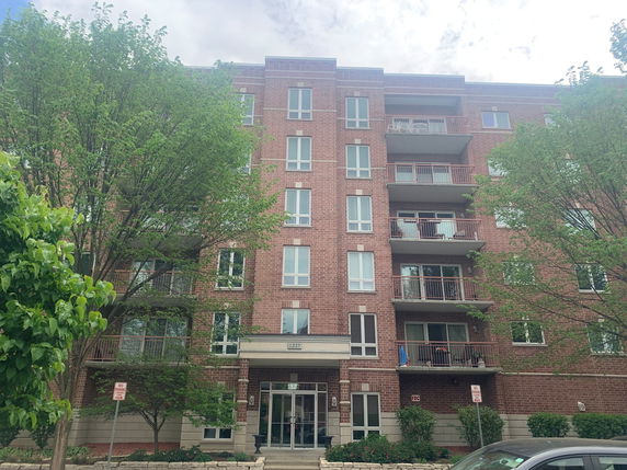 Front view of a brick apartment building with balconies.