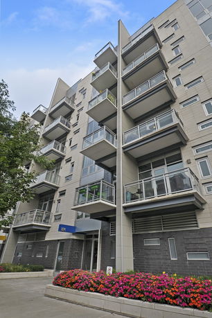 Front view of a multi-story apartment building with balconies.