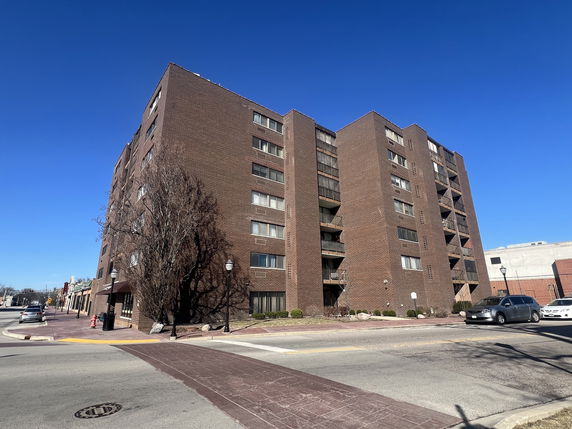 Front view of a multi-story brick apartment building.