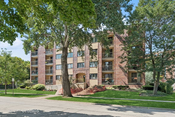 Front view of a multi-story apartment building with brick exterior.
