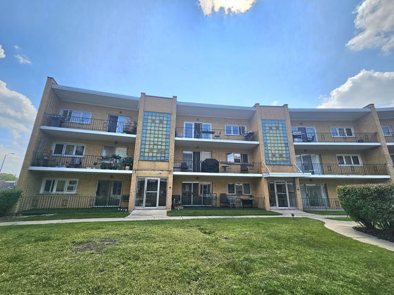 Front view of a multi-story apartment building with balconies.