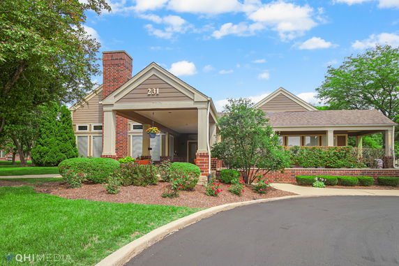 Front view of a single-story brick house with an entrance porch and landscaped garden.