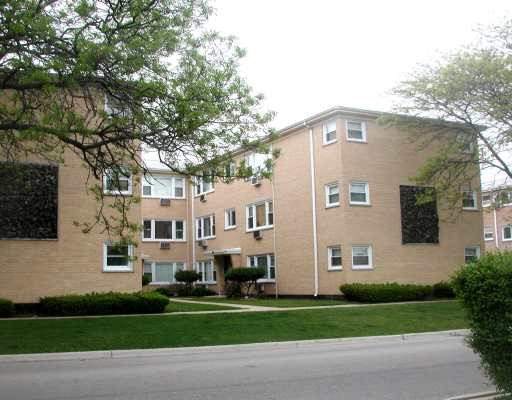 Front view of a multi-story apartment building with brick exterior.
