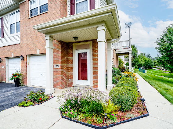 Front view of a two-story house with a garage and red front door.