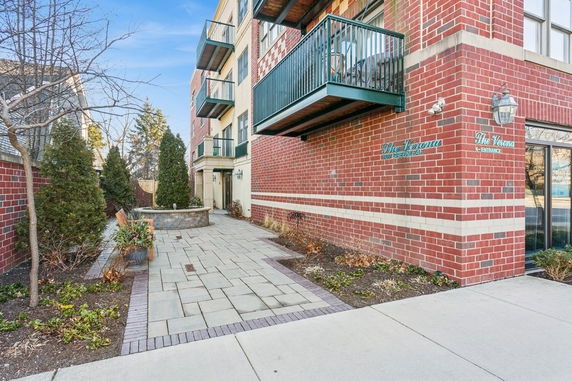 Front view of a multi-story building with balconies and brick exterior.