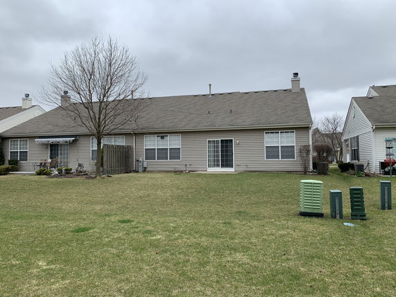Rear view of a single-story house with a large lawn area.
