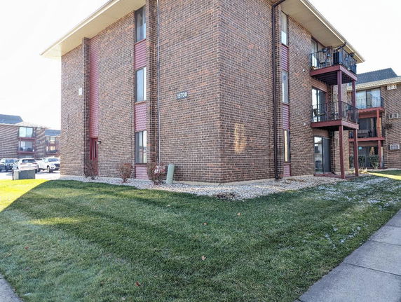 Front view of a multi-story brick building with balconies.
