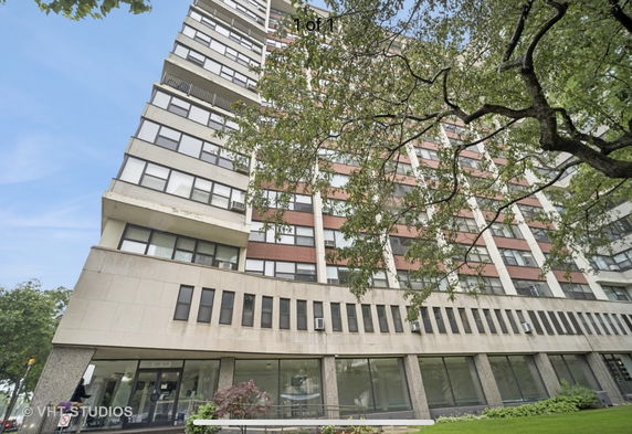 Front view of a multi-story apartment building with large windows.