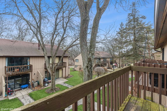 View from a balcony overlooking residential buildings and trees.