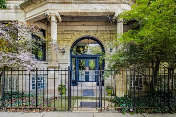 Front view of a building entrance with arched doorway and columns.