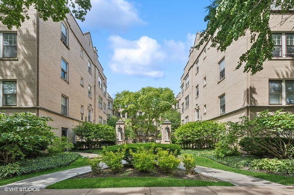 Front view of an apartment building with a garden courtyard.